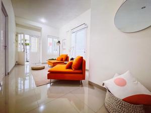 a living room with two orange chairs and a mirror at Villa LA Mansion Lembang in Lembang