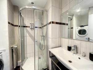 a bathroom with a shower and a sink and a washing machine at Appart XXL -10 pers - 2 Pkg - 10 mn Paris in Épinay-sur-Seine +68 photos