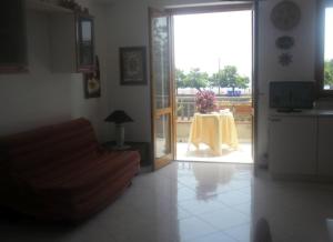 a living room with a table with a yellow table cloth at Casa Le Ancore in Riposto