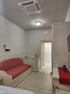 a room with a red bed and a kitchen at Affittacamere Angelica in Bologna +41 photos