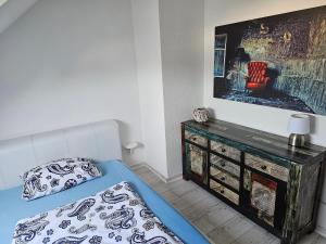 デュースブルクにあるFerienwohnung Glückaufのベッドと壁に絵が飾られた寝室