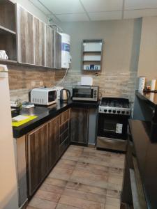 a kitchen with a stove and a microwave at Apart Trelew in Trelew