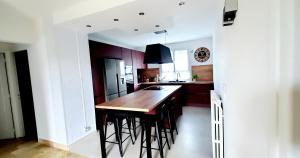 a kitchen with a wooden island with bar stools at Gîte de la valleuse, capacité 12 personnes, idéal pour une grande famille in Senneville-sur-Fécamp +15 photos