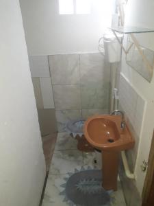 ein kleines Bad mit einem Waschbecken und einem WC in der Unterkunft Casa dos corais in Vila Velha