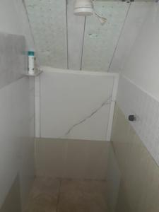 ein weißes Bad mit einer Dusche und einem Spiegel in der Unterkunft Casa dos corais in Vila Velha