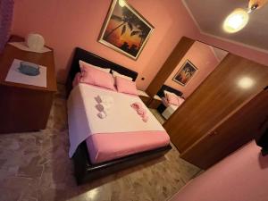 niewielka sypialnia z łóżkiem z różową pościelą i poduszkami w obiekcie Casa Primavera w mieście Mozzate