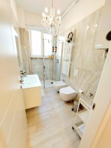 a bathroom with a sink and a toilet and a chandelier at Piccolo Mondo Verona in Verona +44 photos