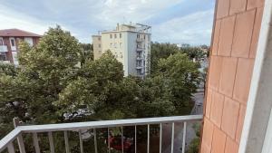 balcone con un edificio bianco e alberi di OLA apartment a Mantova