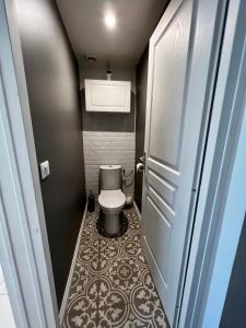 a small bathroom with a toilet and a door at Sweet Abreuvoir in Saint-Germain-en-Laye