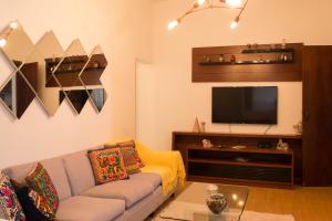 a living room with a couch and a flat screen tv at Recanto da Sol in Belo Horizonte