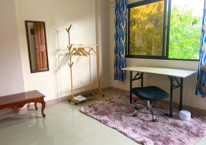 Camera con scrivania, sedia e finestra. di Cozy Studio Apartment with Free Parking a Bayombong