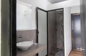 uma casa de banho com um lavatório branco e um chuveiro em Lagarza Hostel em La Libertad