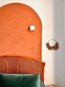 a bedroom with an orange headboard and a green pillow at Aux Arcades Mulhouse Hyper Centre in Mulhouse
