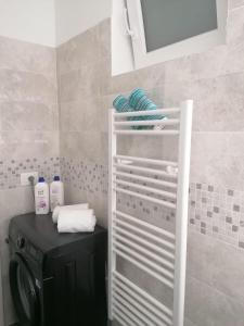 un bagno con lavatrice e asciugamani su una mensola di Dolce Far Niente ad Alassio