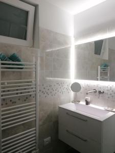 La salle de bains est pourvue d'un lavabo blanc et d'une douche. dans l'établissement Dolce Far Niente, à Alassio