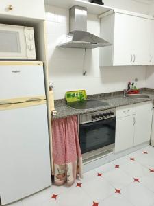 uma cozinha com armários brancos e um forno com placa de fogão em Vista a la sierra em El Astillero