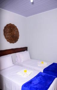 - 2 lits dans une chambre avec des draps blancs et bleus dans l'établissement Pousada Chalés do Toque, à São Miguel dos Milagres
