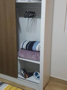 a closet with three towels and a shelf with clothes at Studio 112 Campinas SP in Campinas +25 photos