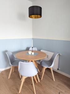 - une salle à manger avec une table et quatre chaises dans l'établissement Vilipa-Apartments Nähe Red Bull Arena, Küche, Smart TV, Badewanne, Maisonette, à Leipzig