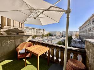 una mesa y sillas en un balcón con sombrilla en BEAUTY 2 WiFi 1 Gbs TV'80 Netflix HBO Disney+ en Varsovia