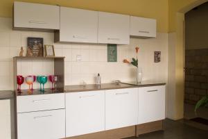 a kitchen with white cabinets and wine glasses on the counter at Recanto da Sol in Belo Horizonte