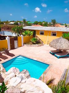 een zwembad voor een geel huis bij Casa di Caribe - tropical beach in Willemstad