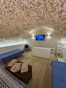 Pokój z kanapą i telewizorem na ścianie w obiekcie Andive w Syrakuzach