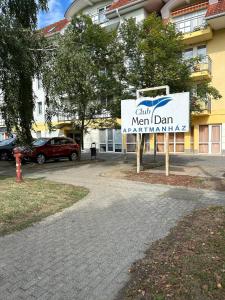 a sign in front of a building with a sign at Dani Wellness Apartman in Zalakaros