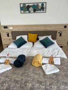 duże łóżko z 3 kocami i poduszkami w obiekcie Dani Wellness Apartman w Zalakaros