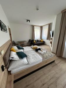 um quarto com uma cama grande e almofadas em Dani Wellness Apartman em Zalakaros