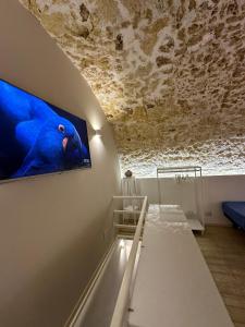 Zimmer mit einem an der Wand hängenden TV in der Unterkunft Andive in Syrakus