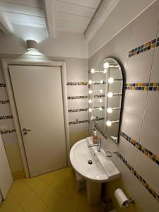 ein Bad mit einem Waschbecken und einem Spiegel in der Unterkunft Andive in Syrakus