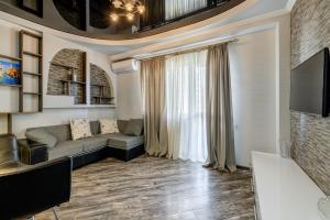 uma sala de estar com um sofá e uma televisão em Cozy Apartment em Tbilisi