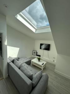 a living room with a couch and a skylight at Modern London Apartment in London