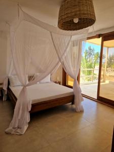 a bedroom with a bed with a mosquito net at Sunny Villa Matemwe in Matemwe