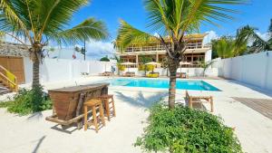 a villa with a swimming pool and palm trees at Sunny Villa Matemwe in Matemwe
