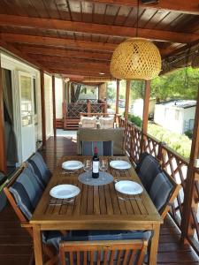 イェゼラにあるMobile home "Sun" Jezera Village , otok Murterの木製テーブルと椅子付きのデッキ