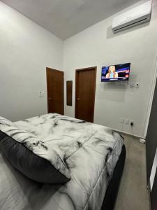 1 dormitorio con 1 cama grande y TV en la pared en Casa a 10 Minutos de la Playa en Nuevo Vallarta Para Máximo 8 Personas, en Mezcales