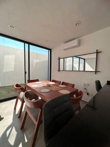 comedor con mesa de madera y sillas en Casa a 10 Minutos de la Playa en Nuevo Vallarta Para Máximo 8 Personas, en Mezcales