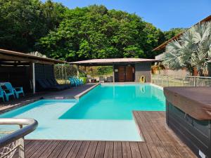 a swimming pool on a deck with a wooden deck at SAS CLP - La Marina in Kourou