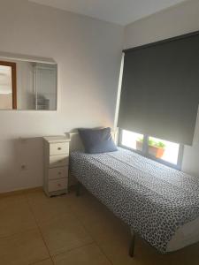 a small bedroom with a bed and a window at Casa Innès in Punta Mujeres