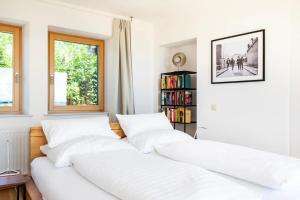 twee witte bedden in een kamer met een boekenplank bij Schilcher-Residenz in Steinreib