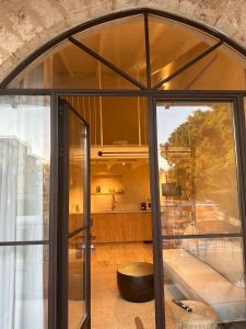 a room with a large glass door and a stool at Hagafen Boutique Suites in Zikhron Ya‘aqov