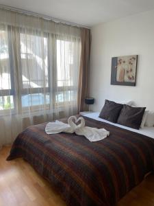 ein Schlafzimmer mit einem Bett mit zwei Handtüchern darauf in der Unterkunft BDA H10 Apartment Budapest in Budapest