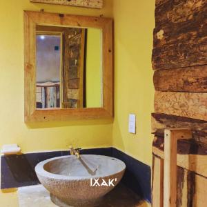 een badkamer met een stenen wastafel en een spiegel bij Ixak Cabañas 