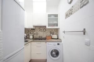 una cocina blanca con lavadora. en Lovely apartment in the old town of Seville, en Sevilla