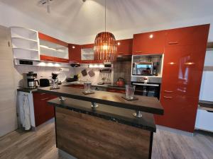 a kitchen with red cabinets and a black counter top at Penthouse-Apartment AM KORNFELD in Lünen