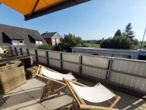 two chairs sitting on a patio with a fence at Penthouse-Apartment AM KORNFELD in Lünen