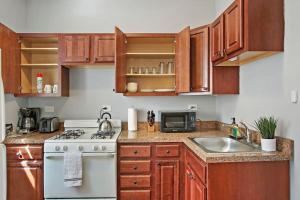 eine Küche mit Holzschränken, einem Herd und einer Spüle in der Unterkunft Enchanting 1-Bedroom Lakeview Apartment - Belmont F6 in Chicago