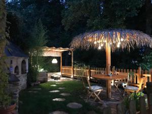 d'une terrasse avec une table en bois et un parasol de chaume. dans l'établissement A curuxa casa rural, 